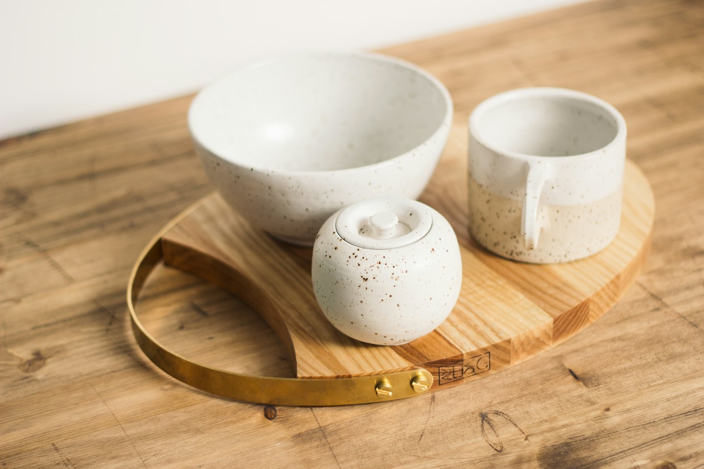 Ceramic bowls and a mug arranged on a wooden board.