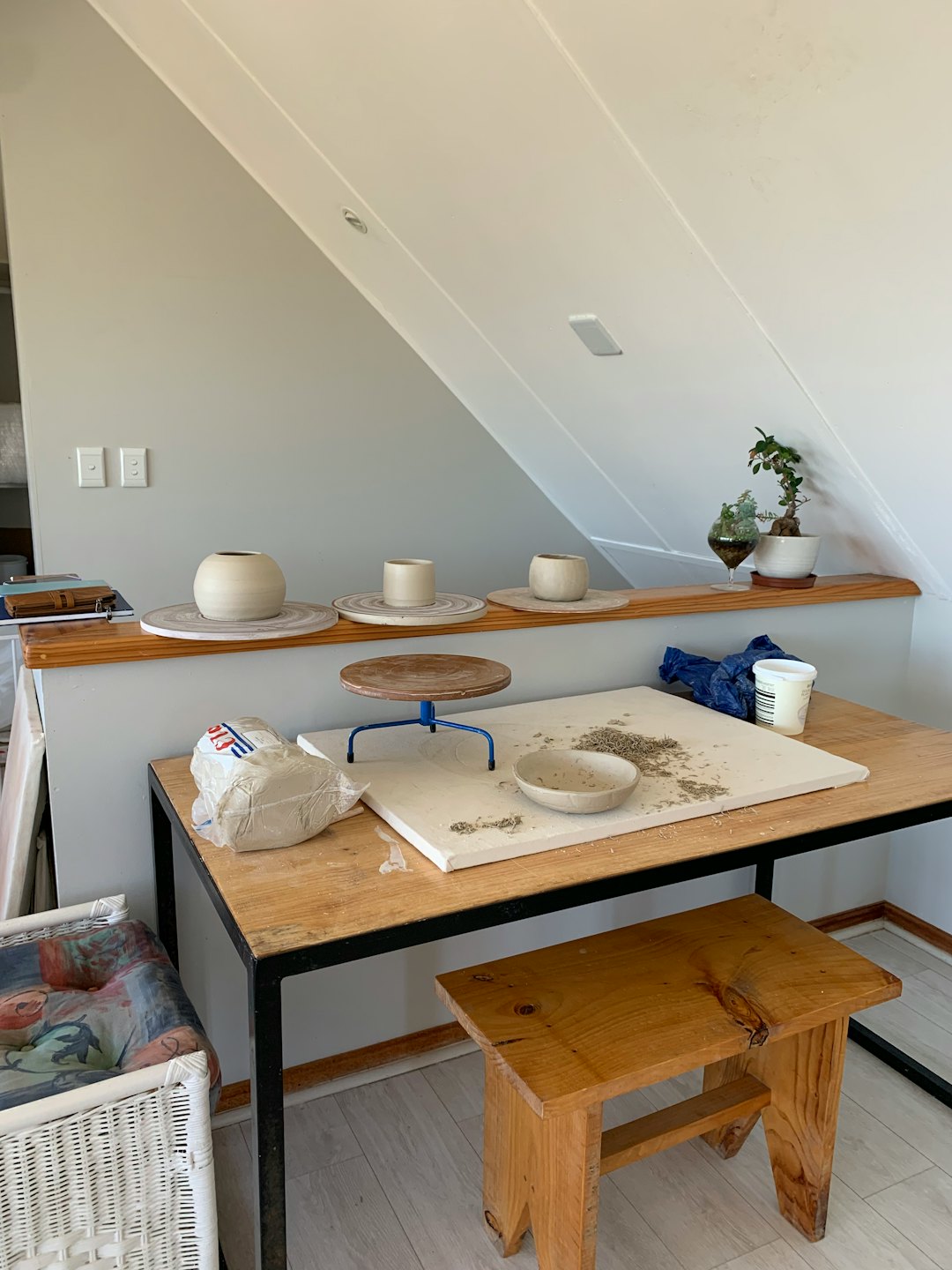 Pottery studio workspace with tools, clay, and finished ceramics.